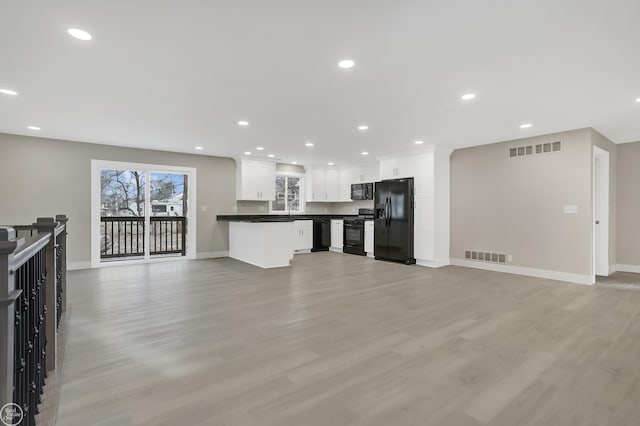 unfurnished living room featuring baseboards, light wood-style flooring, and visible vents