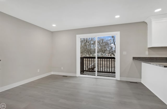 unfurnished dining area featuring visible vents, baseboards, wood finished floors, and recessed lighting