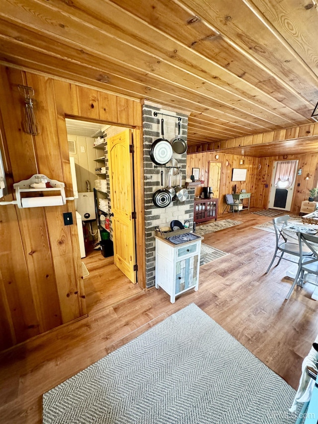 living area with wood ceiling, wood finished floors, and wooden walls