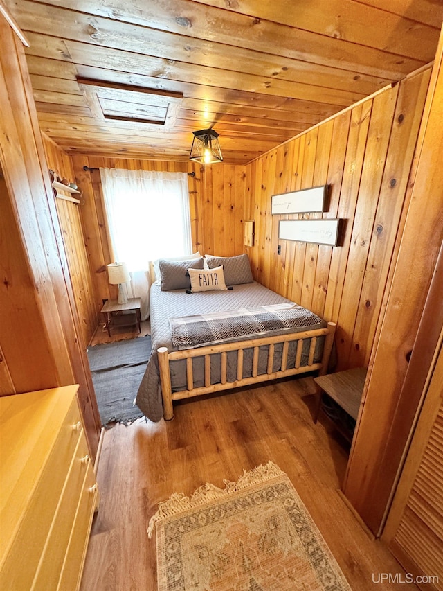 bedroom featuring wood ceiling, wood finished floors, and wood walls