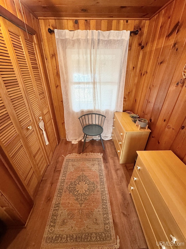 sitting room with wood walls and wood finished floors