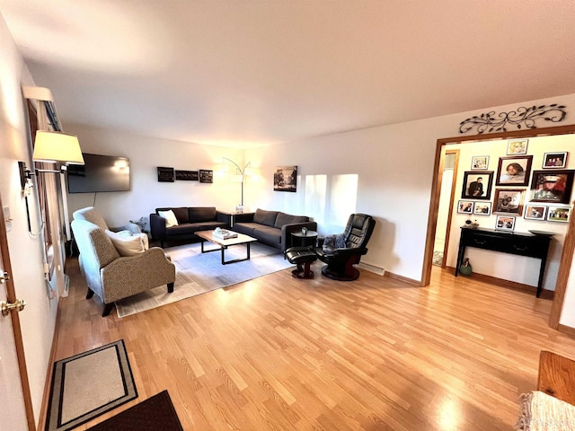 living room with baseboards and wood finished floors