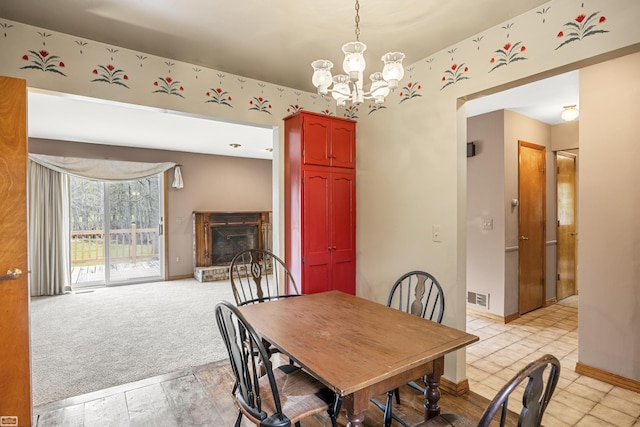 475 S Bartlett Rd, Saint Clair, MI 48079 - dining area with a fireplace with raised hearth, visible vents, baseboards, and a notable chandelier