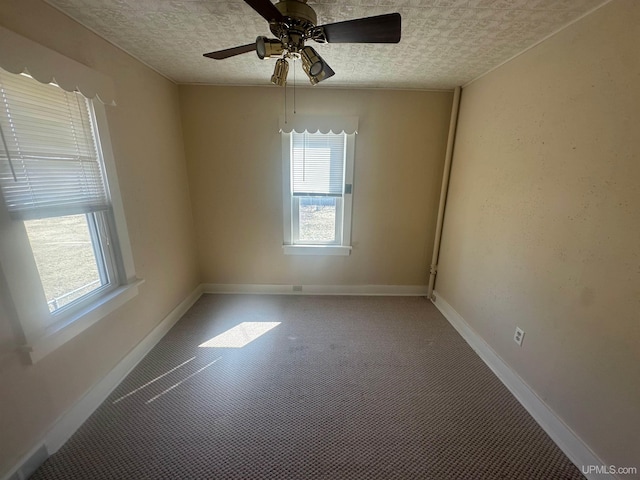 empty room featuring baseboards, plenty of natural light, and ceiling fan