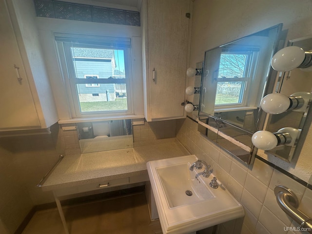 bathroom featuring a sink and backsplash