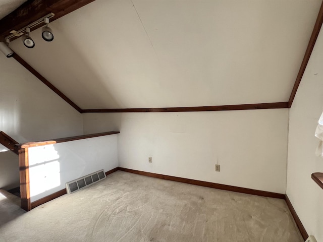 additional living space featuring light carpet, lofted ceiling, visible vents, and baseboards