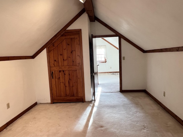 bonus room featuring light carpet, baseboards, and lofted ceiling with beams