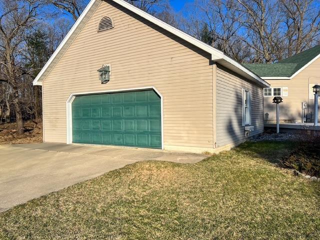 view of side of property featuring a lawn and a garage