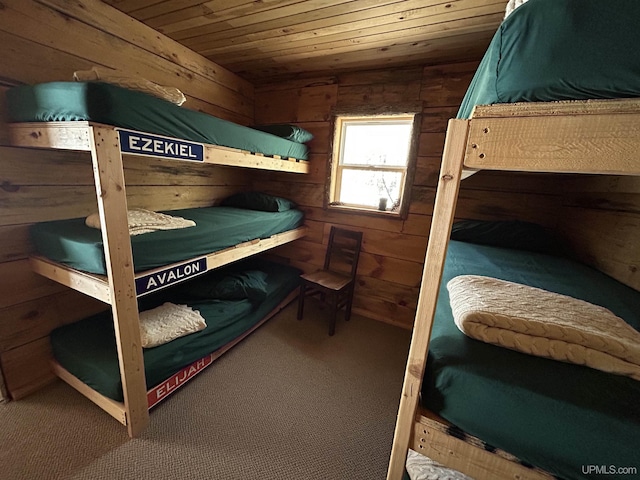 bedroom with wood ceiling, wood walls, and carpet flooring