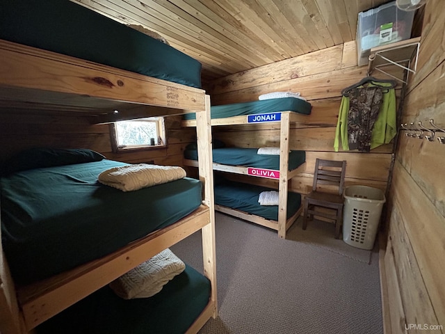bedroom with wood ceiling, wood walls, and carpet floors