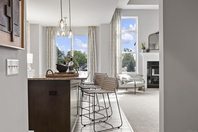 dining space with a glass covered fireplace and wood finished floors