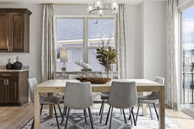 dining space featuring light wood-type flooring and a chandelier