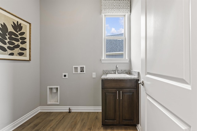 washroom with a sink, baseboards, washer hookup, electric dryer hookup, and dark wood-type flooring