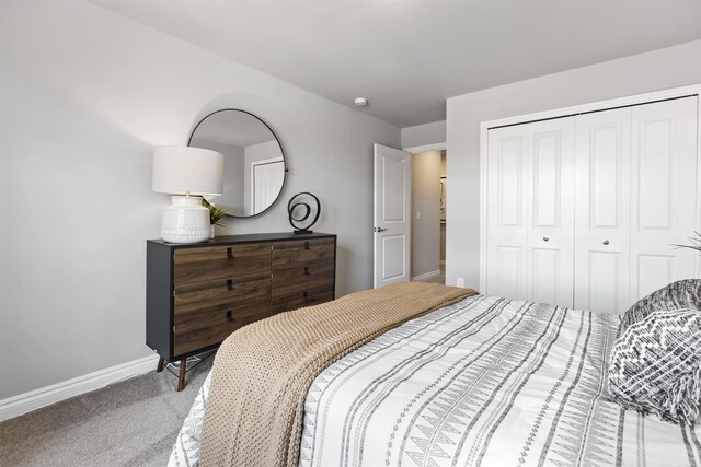 carpeted bedroom with a closet and baseboards