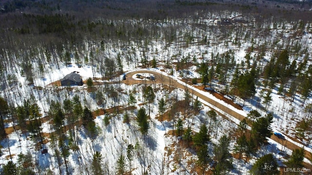 snowy aerial view with a wooded view