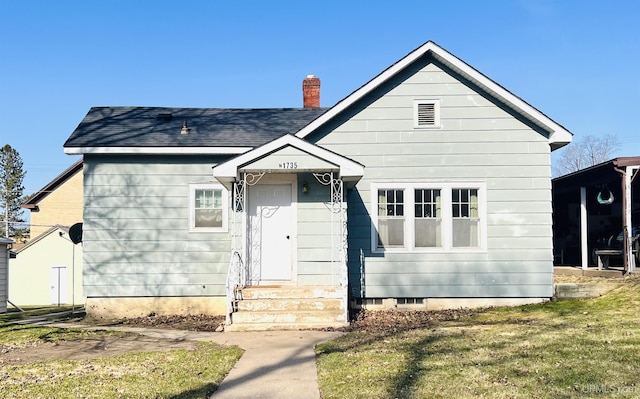 bungalow featuring a chimney, a front lawn, and crawl space