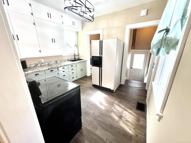 kitchen featuring a sink, dark wood-style flooring, black / electric stove, light countertops, and white fridge with ice dispenser