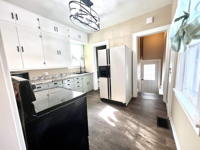 kitchen featuring a sink, black range with electric cooktop, white fridge with ice dispenser, an inviting chandelier, and dark wood-style flooring