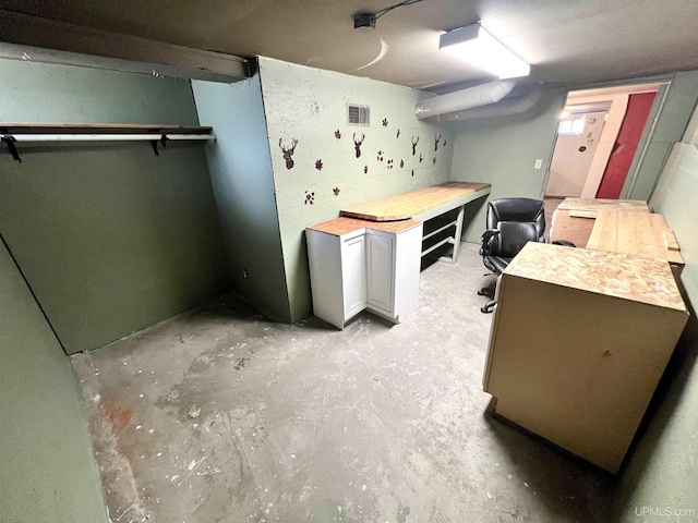 home office featuring concrete flooring and visible vents