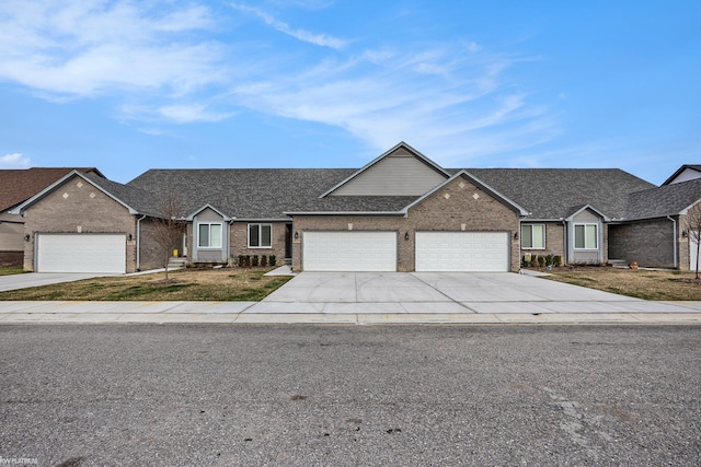 ranch-style house featuring brick siding, driveway, roof with shingles, and a garage
