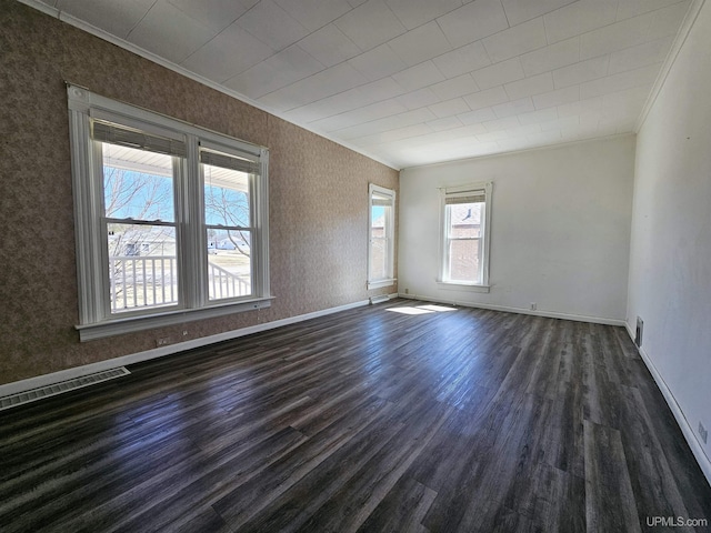 unfurnished room with dark wood finished floors, visible vents, crown molding, and baseboards