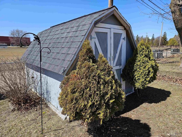 view of outbuilding featuring fence
