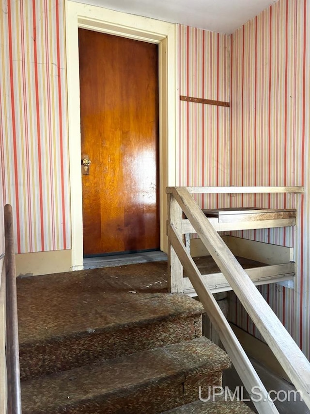 stairway featuring wallpapered walls