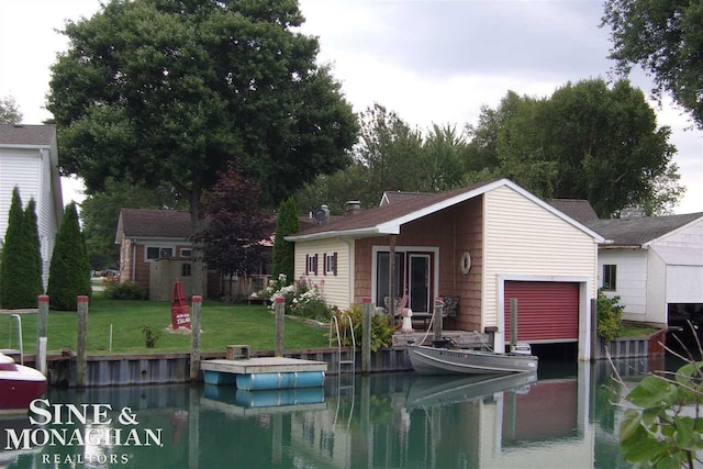 exterior space with a lawn, a dock, an outdoor structure, and a water view