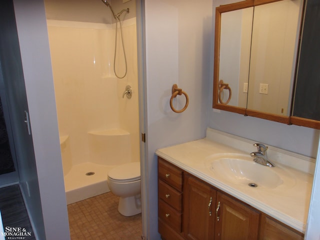 bathroom featuring toilet, walk in shower, and vanity
