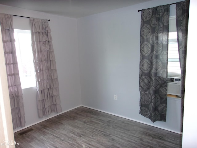 spare room featuring visible vents, wood finished floors, and cooling unit