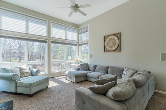 carpeted living area with a ceiling fan