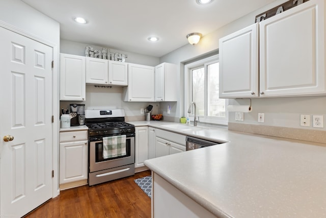 kitchen with stainless steel gas range, white cabinetry, and a sink