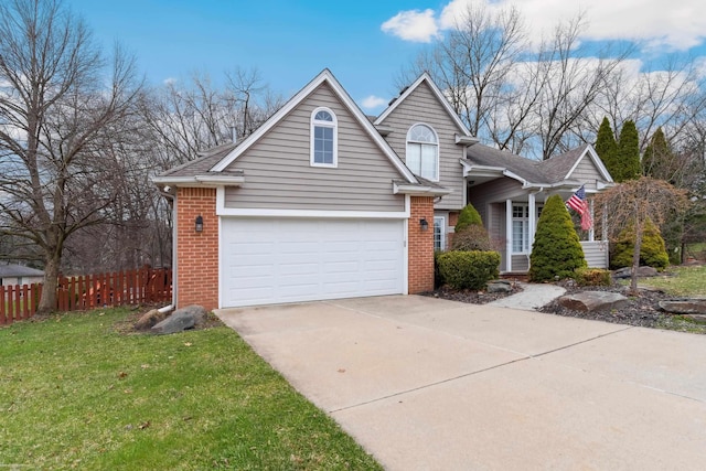 traditional-style house with fence, an attached garage, driveway, brick siding, and a front yard