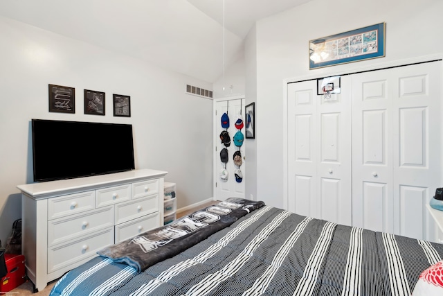 bedroom featuring baseboards, vaulted ceiling, visible vents, and a closet
