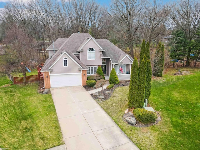 traditional-style house featuring fence, concrete driveway, an attached garage, brick siding, and a front yard