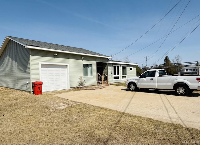exterior space with an attached garage, a shingled roof, and driveway
