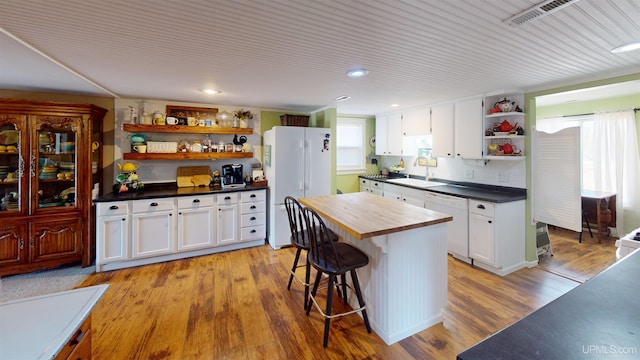 kitchen featuring open shelves, white appliances, a wealth of natural light, and a sink
