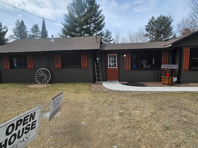 ranch-style house featuring roof with shingles and a front lawn