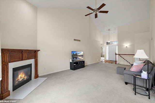 living area with high vaulted ceiling, a fireplace, light colored carpet, a ceiling fan, and visible vents