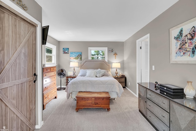 bedroom featuring light colored carpet, baseboards, and multiple windows