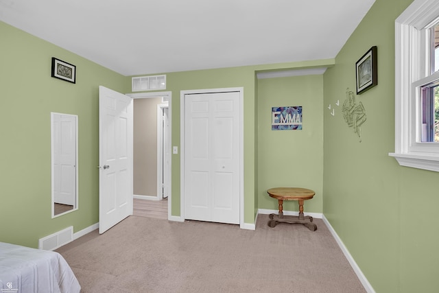 carpeted bedroom with baseboards, visible vents, and multiple windows