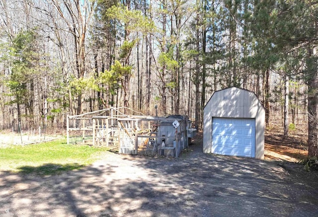 detached garage with a view of trees