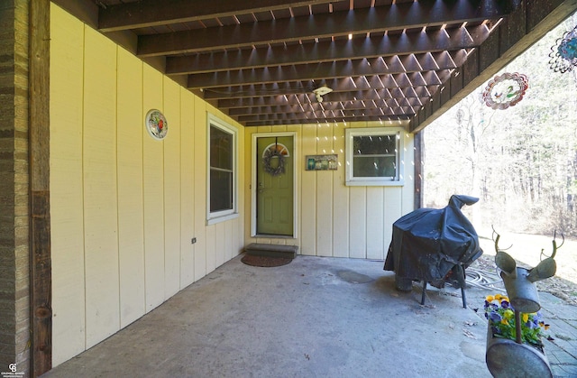 property entrance featuring a pergola and a patio