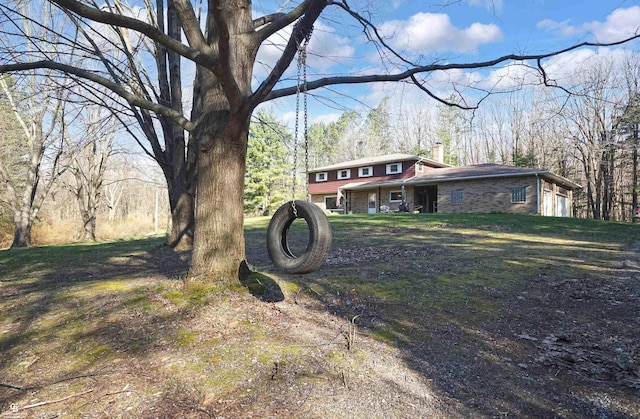 exterior space featuring a garage, brick siding, and a chimney