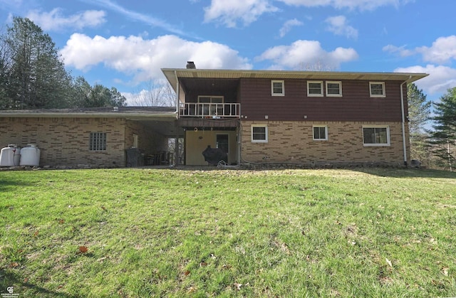 back of property featuring a lawn, a chimney, and brick siding