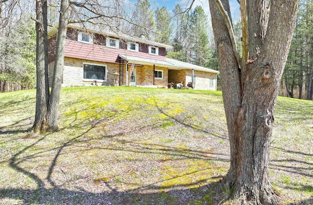 view of front of house with stone siding and a front lawn