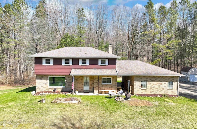 view of front of home with a chimney, a front lawn, and brick siding