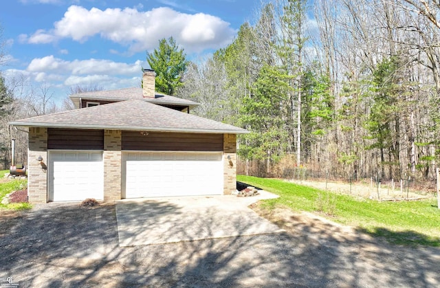 view of home's exterior with a chimney, driveway, a garage, brick siding, and roof with shingles