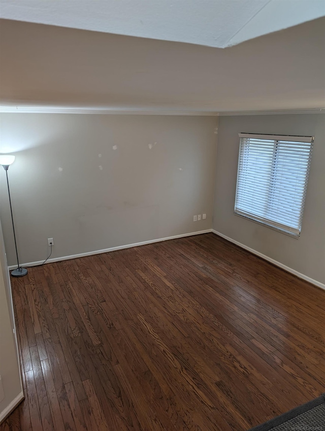 unfurnished room featuring baseboards and dark wood-style floors