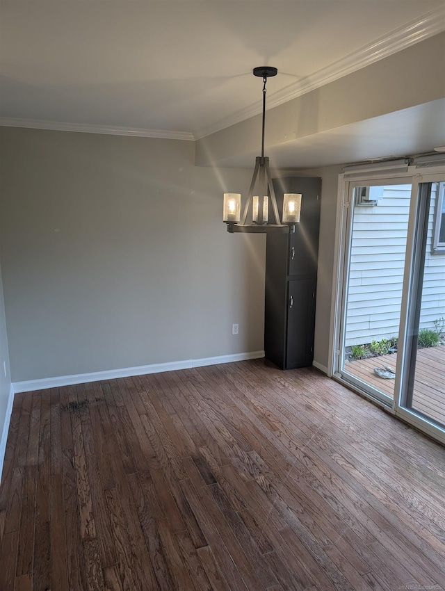 unfurnished dining area featuring dark wood-type flooring, a chandelier, baseboards, and ornamental molding